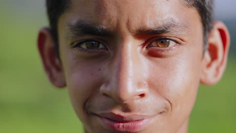 emotionally tense indian village boy in paddy landscape, shifting gaze and appearing troubled, 4k video