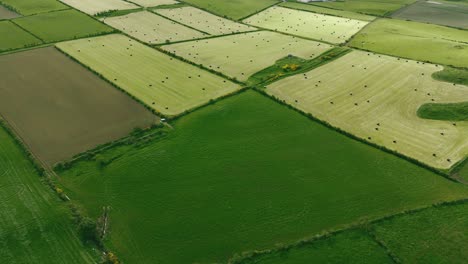 Ballycastle-fields-of-Northern-Ireland-with-perfect-segmented-plots-of-light-and-dark-green,-aerial-high-angle-dolly