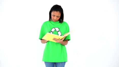 Pretty-female-environmental-activist-doing-homework-writing-into-a-folder