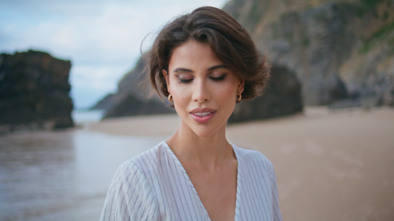 Ritratto di modella in posa sulla costa di un'isola rocciosa. Donna attraente e calma che passeggia sulla spiaggia.