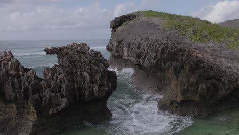 Un-Primer-Plano-Revela-Una-Toma-De-Un-Dron-De-La-Pared-Rocosa-De-La-Isla