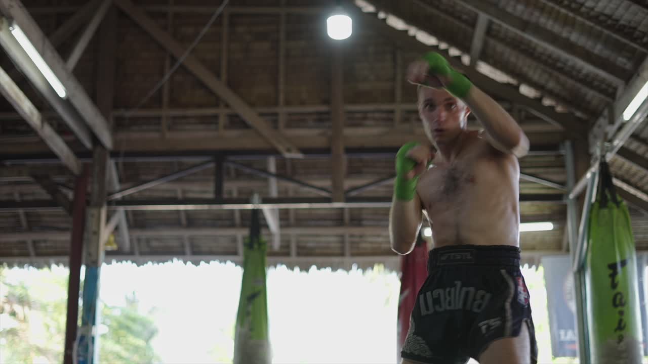 Man Training Muay Thai in a Gym