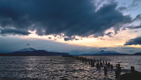 tranquilo metraje de 4k de un viejo muelle de madera y las olas del océano al atardecer en puerto natales, patagonia chilena