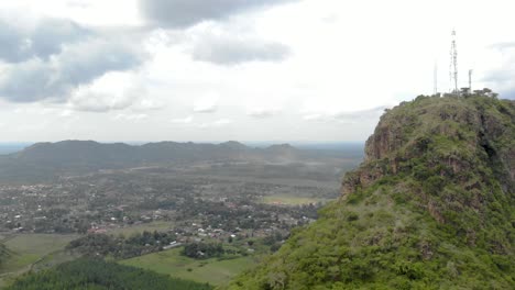 Toma-Aérea-Avanzando-Hacia-Un-Paisaje-Africano-Rural-Con-Acantilados-Y-Montañas