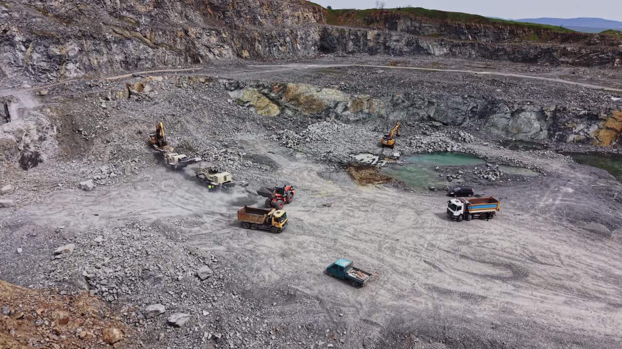 Aerial View of Heavy Machinery Working in a Large Open-Pit Quarry