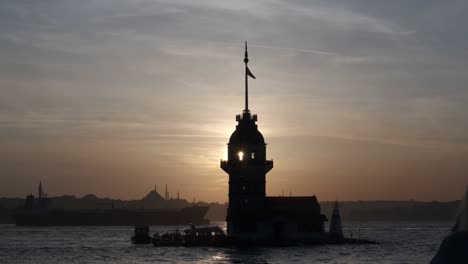 silhouettes of the maidens tower at sunset with tanker ship