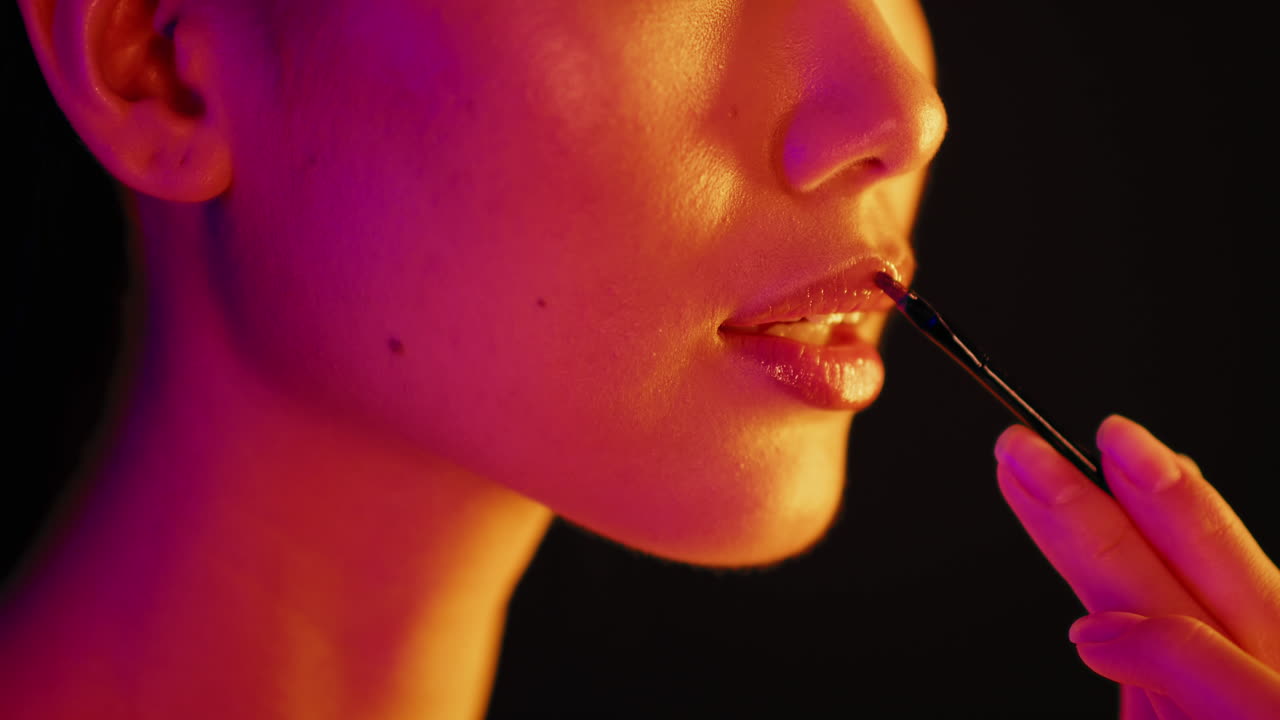 Woman Applying Lipstick in Neon Light
