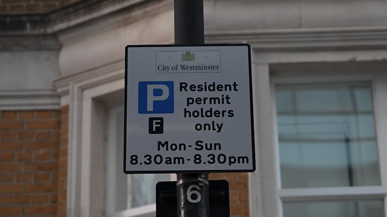 Značka pouličního parkování s uvedením, že parkování je vyhrazeno pouze pro držitele povolení v City of Westminster, znázorňující řízená místní pravidla parkování a městské regulace