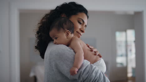 Madre-Feliz-Sosteniendo-Al-Bebé-Calmando-A-Su-Hijo-Recién-Nacido-Mamá-Calmando-Suavemente-Al-Bebé-Disfrutando-De-La-Maternidad-En-Casa-4k