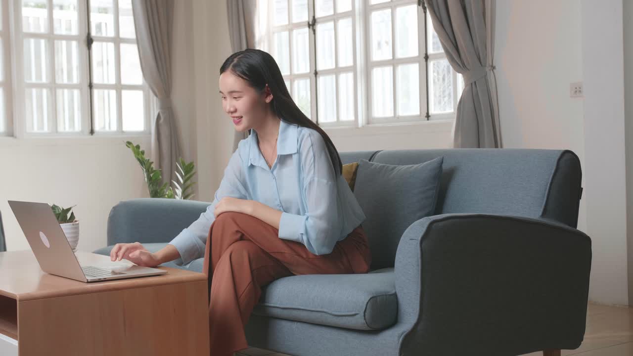 Asian Woman Sitting Sofa Use Laptop Computer And Rest In Home Living Room, Video In 4K