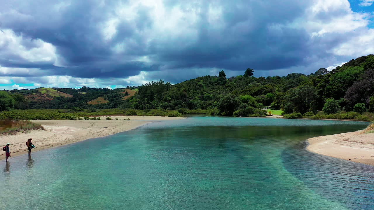 la gente se para en la costa de un río poco profundo en nueva zelanda