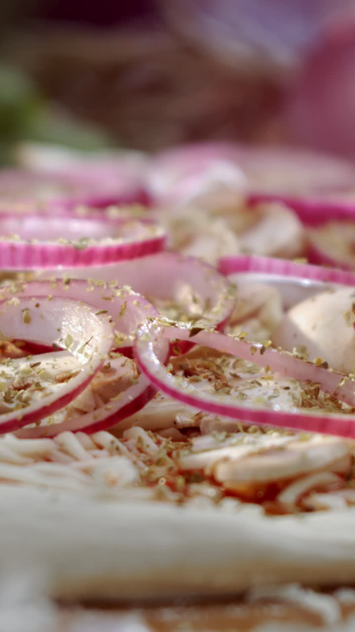 Making pizza with red onions and oregano