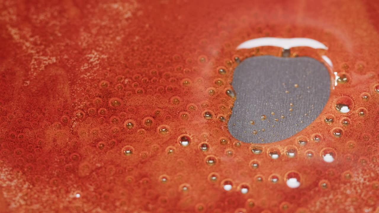 Orange Liquid with Bubbles and a Dark Spot