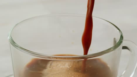 pouring coffee into a glass cup