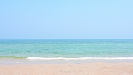 Playa-De-Arena-Vacía-Y-Mar-Esmeralda-Tranquilo-Mareas-Espumosas-Rodando-Sobre-La-Arena-En-Una-Isla-Deshabitada-En-Tailandia,-Cielo-Despejado,-Plantilla-De-Vacaciones,-Espacio-De-Copia-Minimalista-Sin-Gente