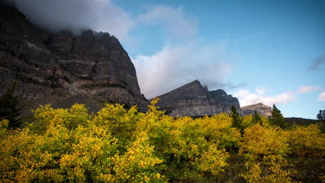 lapso de tiempo, naturaleza prístina del parque nacional de los glaciares en la temporada de otoño, nubes sobre picos y follaje amarillo, montana, ee.uu.