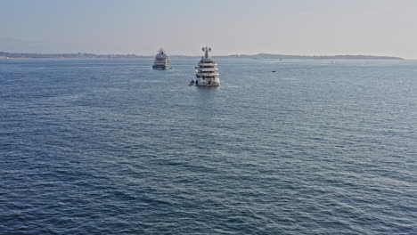 cannes france aerial v19 cinematic drone forward flying toward horizon, passing three luxurious superyachats cruising on mediterranean sea during daylight - july 2021