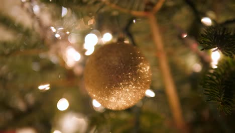 Glitzerndes-Goldenes-Ornament,-Das-Am-Weihnachtsbaum-Hängt