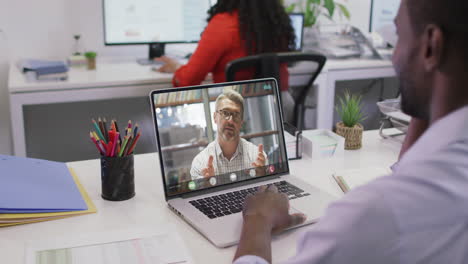 Video-of-african-american-man-having-video-call-on-laptop-with-caucasian-male-coworker