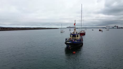 anchored fishing trawler aerial view circling holyhead breakwater coastal marina wall