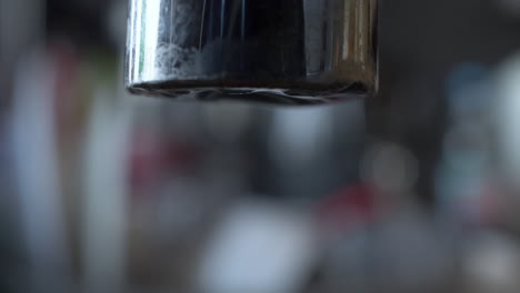 Macro-Close-Up-Of-Slow-Drip-From-End-Of-Tap-With-Bokeh-Background