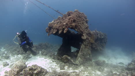 Scuba-Diver-Observando-El-Naufragio-De-Una-Grúa-Desde-El-Frente-En-Filipinas