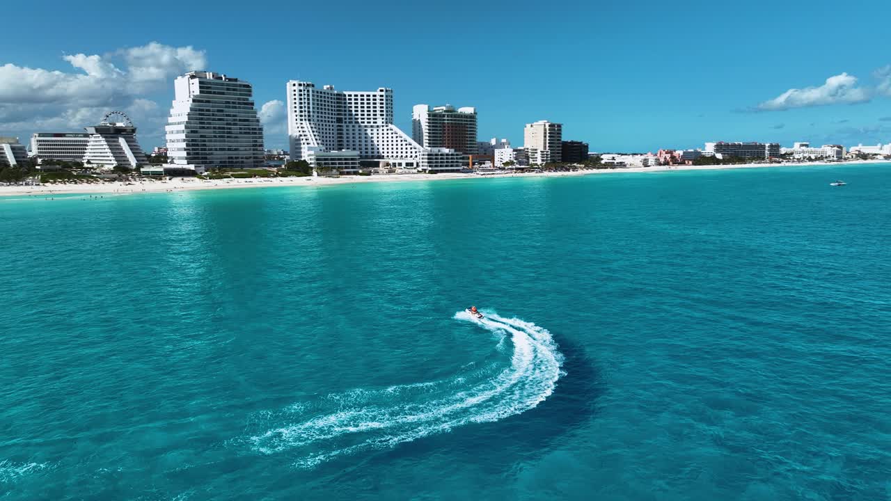 Vista aerea che segue una moto d'acqua davanti alla Zona Hotelera, nella soleggiata Cancun, Messico.