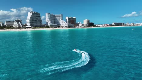 aerial view following a water scooter in front of the hotel zone, in sunny cancun, mexico