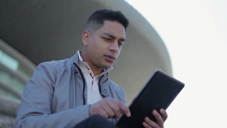 Confident middle eastern businessman working with tablet