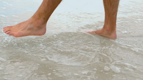 low section of man standing on the sea at beach 4k