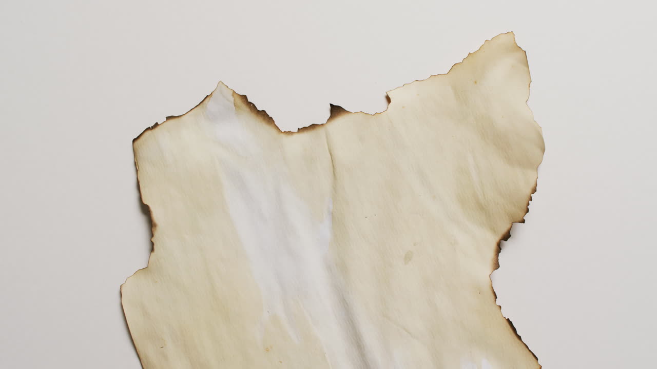 ⁇  배경 에 불타진 가장자리 를 가진 종이 조각 의 클로즈업 영상
