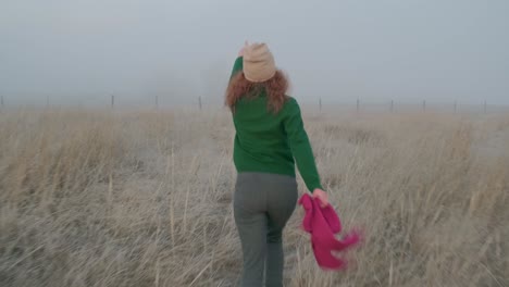 woman running through a foggy field