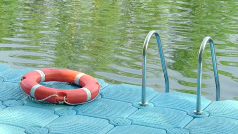 life buoy on surface of blue plastic pontoon walkway for rescue in case of emergency