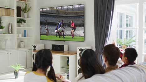 composite of happy family sitting at home together watching rugby match on tv