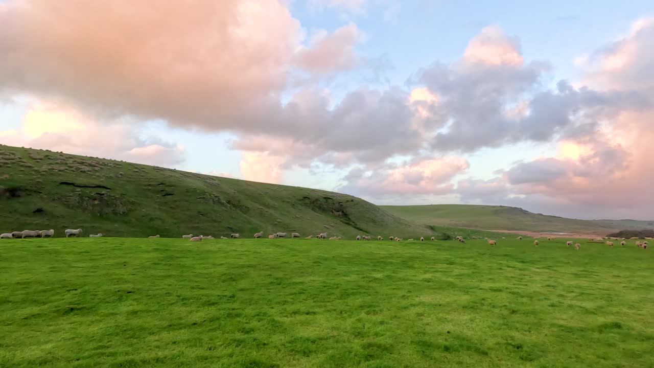A tranquil scene of rolling green hills under a vibrant sunset sky, capturing the peaceful essence of rural Australia