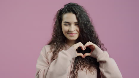 mujer haciendo forma de corazón con las manos