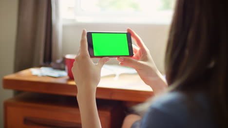 a woman watching content on her smartphone at home