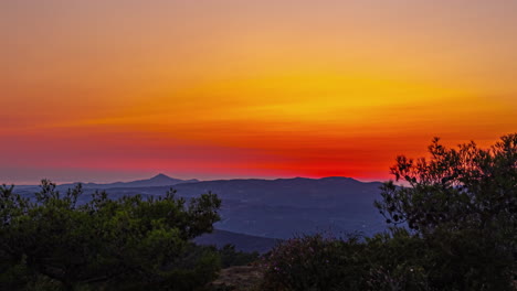 Zeitrafferaufnahme-Des-Sonnenuntergangs-Im-Hintergrund-über-Einer-Mit-Grüner-Vegetation-Bedeckten-Bergkette-Am-Abend
