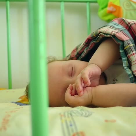 sleeping baby covered in the crib