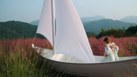 Herb Island Farm- Toddler Girl Pretend Being Captain Playing with Oar Inside Wooden Sail Boat at Pink Muhly Grass Field - in Pocheon