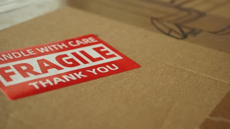 close-up of a 'fragile handle with care' sticker on a cardboard box