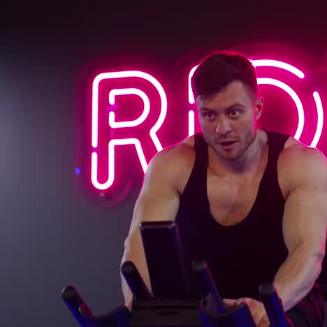 sportman riding bike at the gym. man performs aerobic endurance training on the simulators in the gym