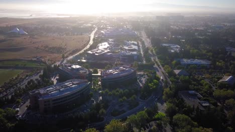 aerial drone view of google campus called googleplex headquarters in silicon valley hold shot as early morning sun rays glaring on solar panels on the rooftop
