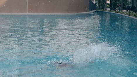 athletic lady jumps into water in hotel pool slow motion