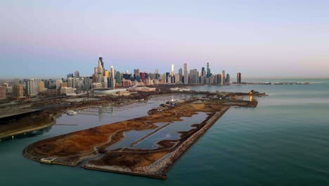 Vista-De-Seguimiento-Aéreo-De-La-Isla-Del-Norte-Y-El-Horizonte-De-Chicago,-Durante-El-Amanecer