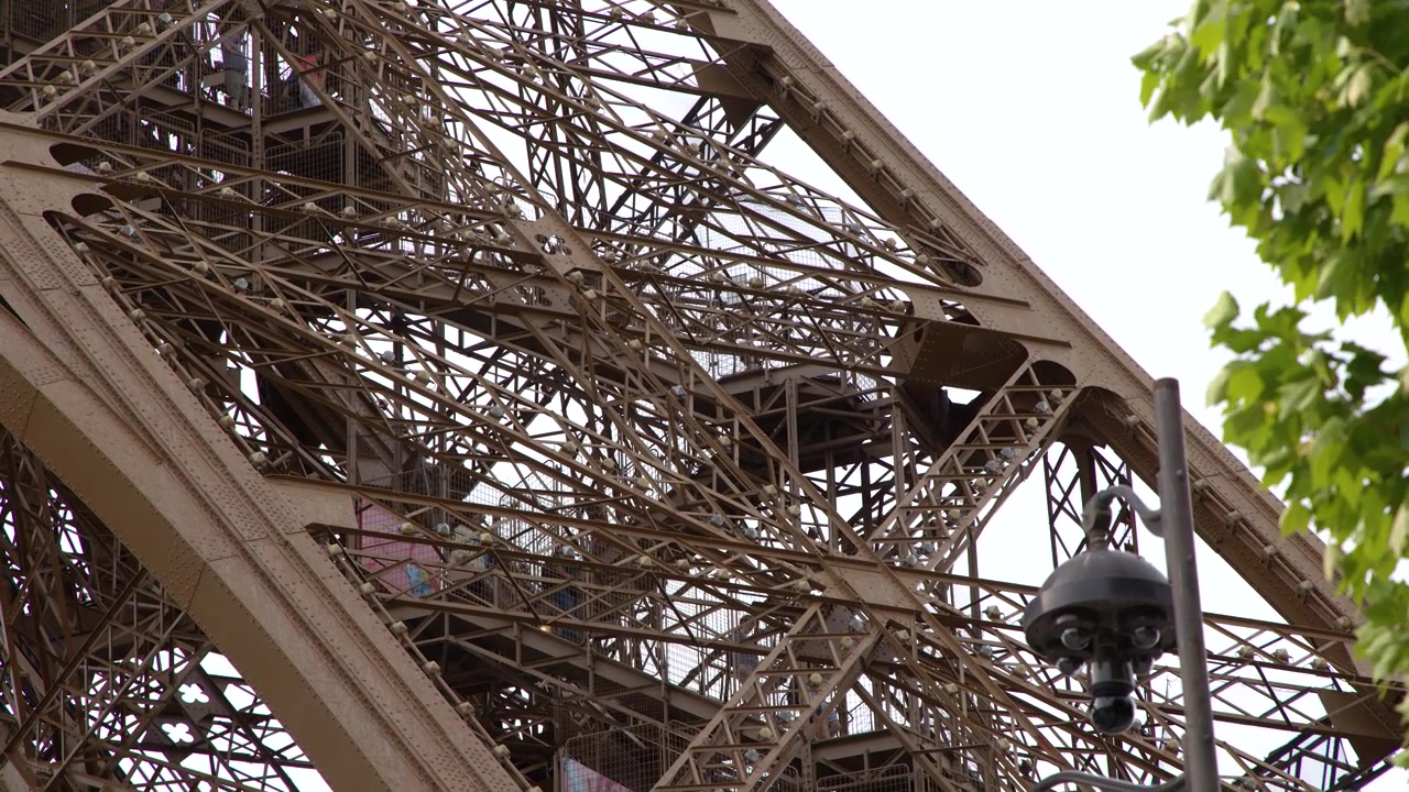 Close-up shot of the intricate ironwork and architectural details of the Eiffel Tower in Paris