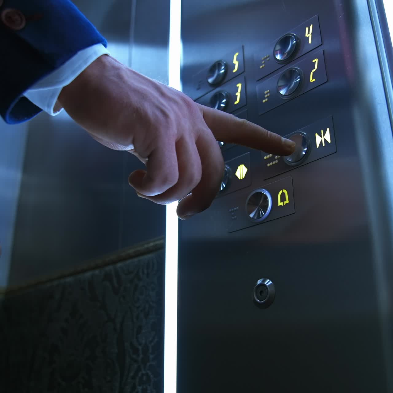 Businessman in lift. Male's hand pressing button to start moving inside the elevator. Man touches elevator button in hotel or high-rise building