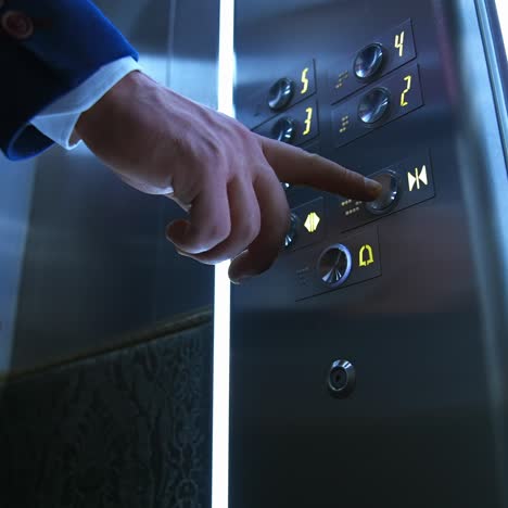 businessman in lift. male's hand pressing button to start moving inside the elevator. man touches elevator button in hotel or high-rise building