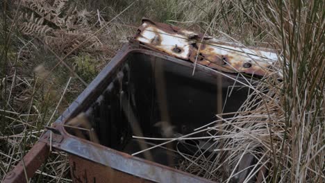 toma manual de desechos ilegales tirados en la naturaleza, metal oxidado en un campo