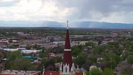 drone parallax above gothic revival spire with cross over pueblo colorado